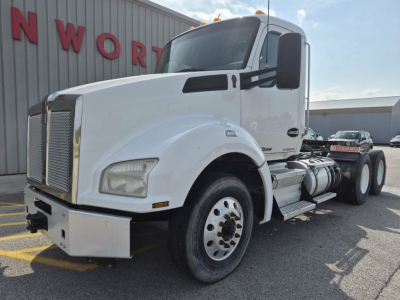 White Kenworth T880 daytime cab tractor front-left view with steps and fuel tanks visible, side mirrors, large grille, and wheel with dual rear axles.