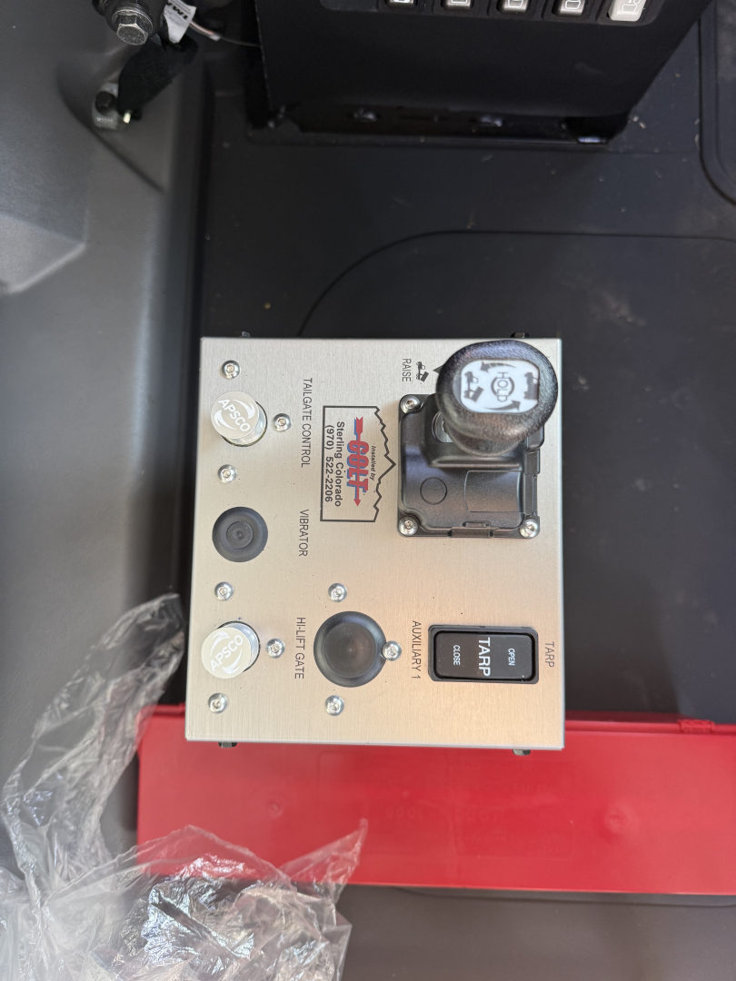 Panel with control switches and gauge on Mack truck dash showing chrome metal panel with labeled switches and a large round knob, plus a small sticker reading 'Diesel Generator' and 'Air Start'