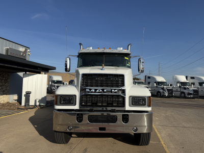 Front view of a Mack PI64 dump truck showing large grille with 'MACK' emblem, dual headlights, chrome bumper, and vertical exhaust stacks.
