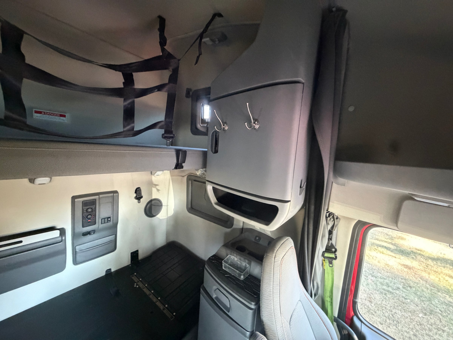 Volvo VNL cab interior showing dashboard controls, overhead compartments, and driver seat area.