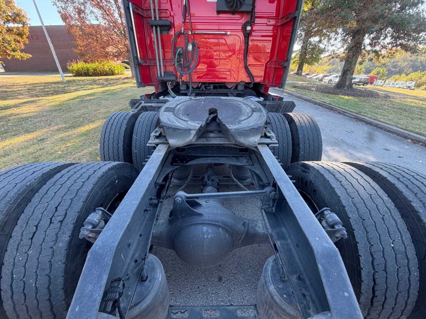 Volvo VNL chassis rear view showing fifth wheel, drive axles, suspension levers, and dual rear wheels with visible air lines and frame rails.