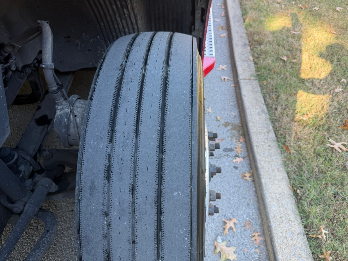 Front left tire and undercarriage of 2022 Volvo VNL64T760; visible text on tire sidewalls and components.