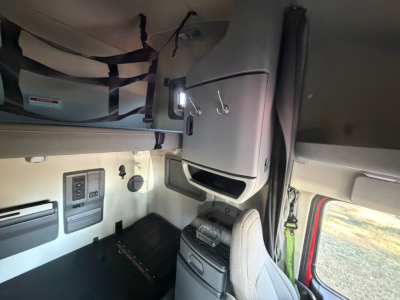  Volvo VNL cab interior showing dashboard controls, overhead compartments, and driver seat area.