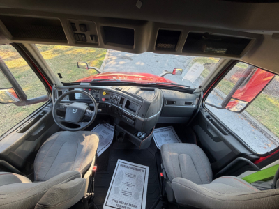 Volvo VNL64T760 truck cockpit interior view from driver’s seat showing dashboard, steering wheel, and front seats.