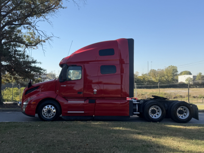 Side view of a red 2022 Volvo VNL64T760 semi-truck tractor with sleeper cab, taken in daylight.