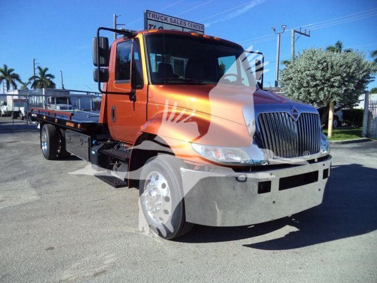 2019 International 4300 rollback truck in service showing front grille and cab with orange paint.