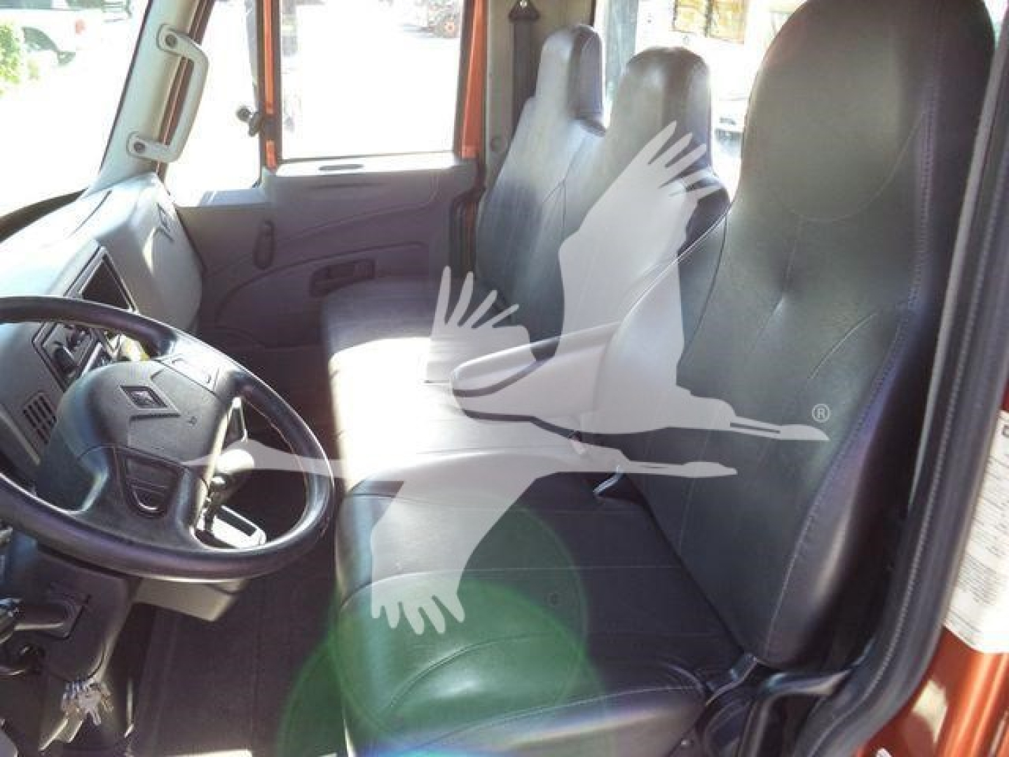 Truck cab interior of a 2019 International 4300 rollback showing driver seat and passenger seat with steering wheel and dashboard.