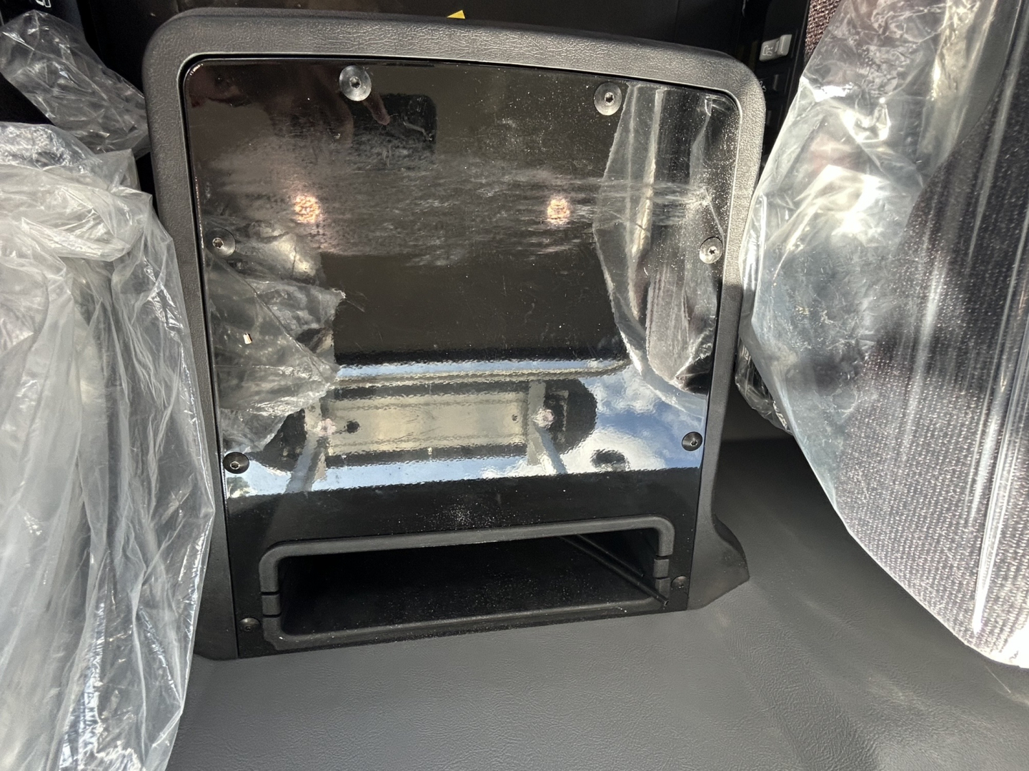 Mack GR84FT cab interior showing storage compartment and protective plastic coverings.