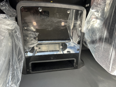 Mack GR84FT cab interior showing storage compartment and protective plastic coverings.