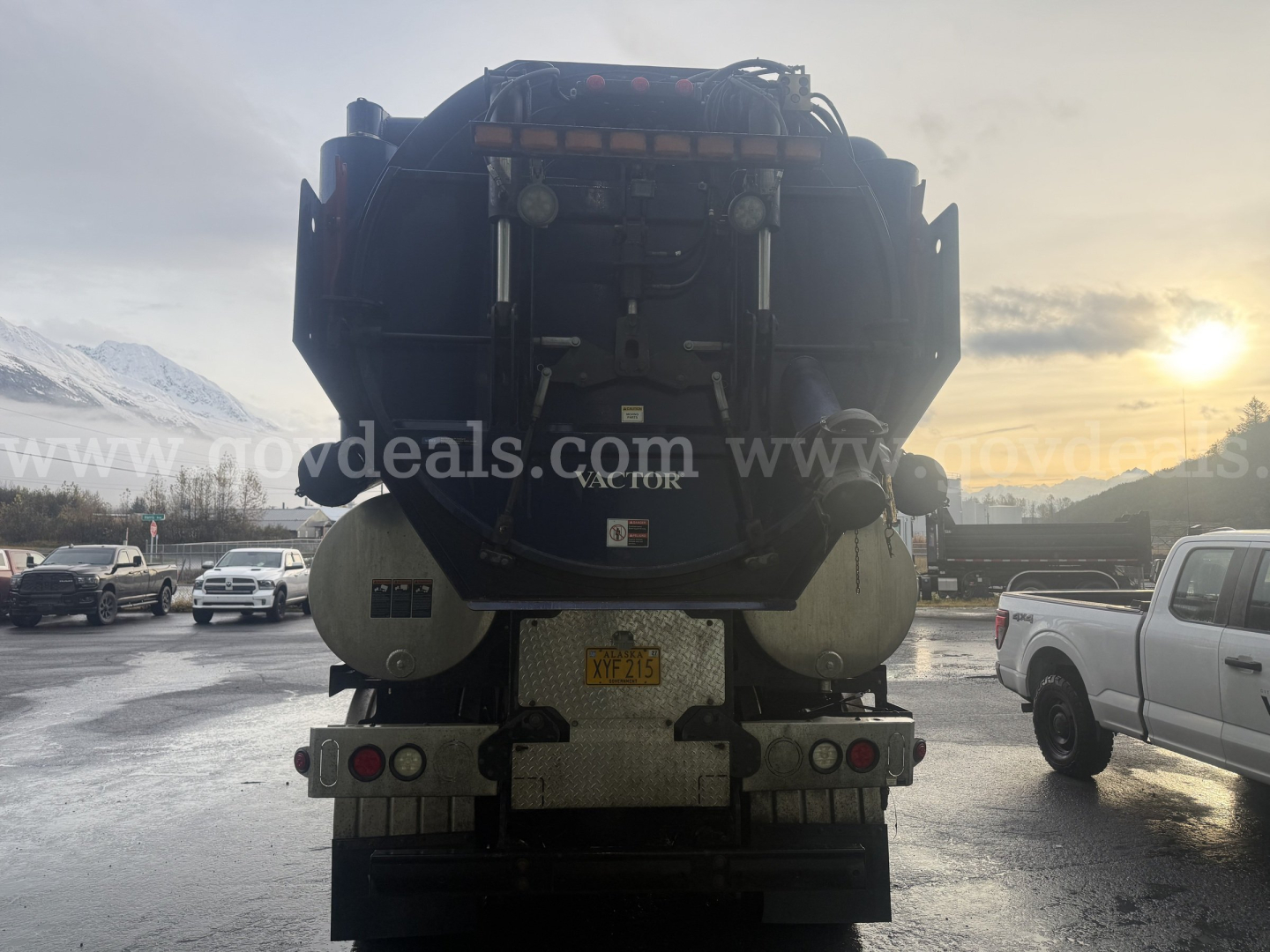 Back view of a large vacuum truck (International WorkStar 7500) showing rear tank, taillights, bumper, and license plate area with rugged equipment.