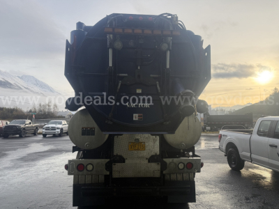 Back view of a large vacuum truck (International WorkStar 7500) showing rear tank, taillights, bumper, and license plate area with rugged equipment.