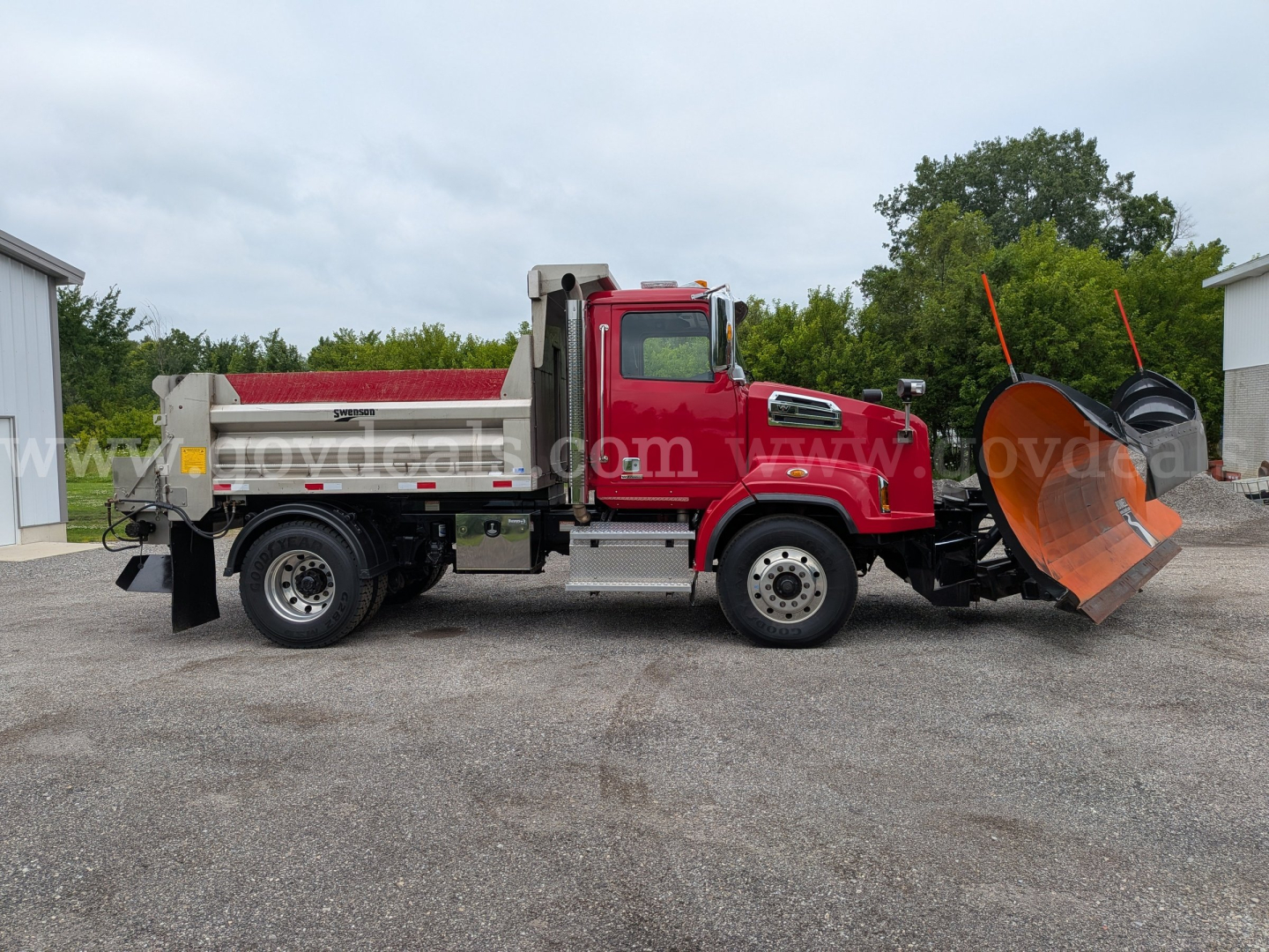 Western Star 4700 plow truck in side view, red cab, with large orange snow plow blade attached, grille, fuel tank, and flatbed bed.