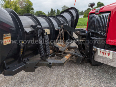 Truck front view showing Western Star 4700 plow truck with snow plow attachment and hydraulic components connected to red cab.