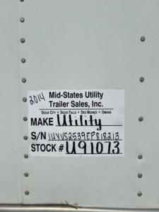 ID plate on utility van side showing Make Utility and S/N U91073 with VIN 1UYVS2539EP818213 and stock number U91073.
