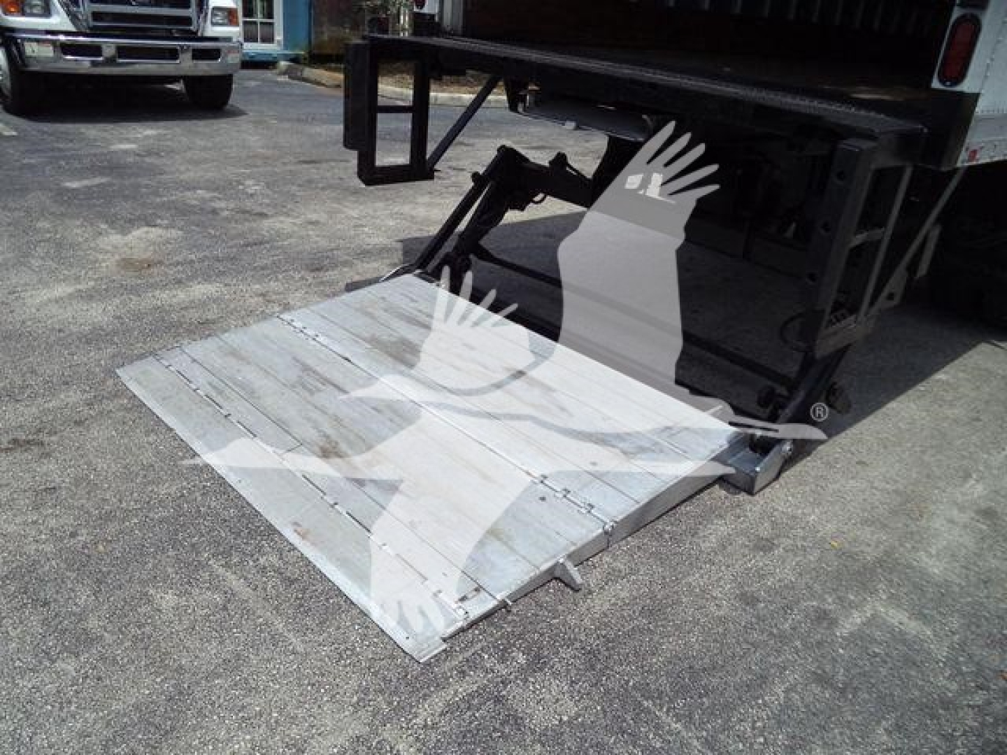 Truck with folded aluminum liftgate in lowered position showing platform and hydraulic arm assembly; Mack MD7 equipment context implied by listing.