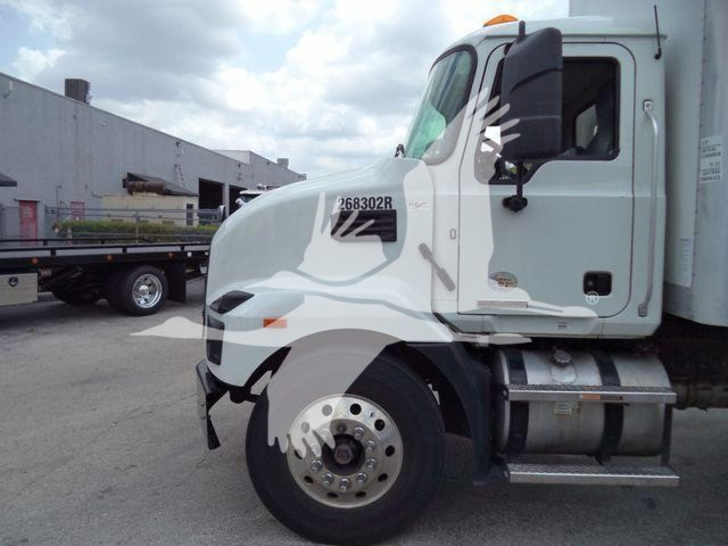 Mack MD7 truck cab side view showing VIN sticker 268302R on door and heavy front wheel.