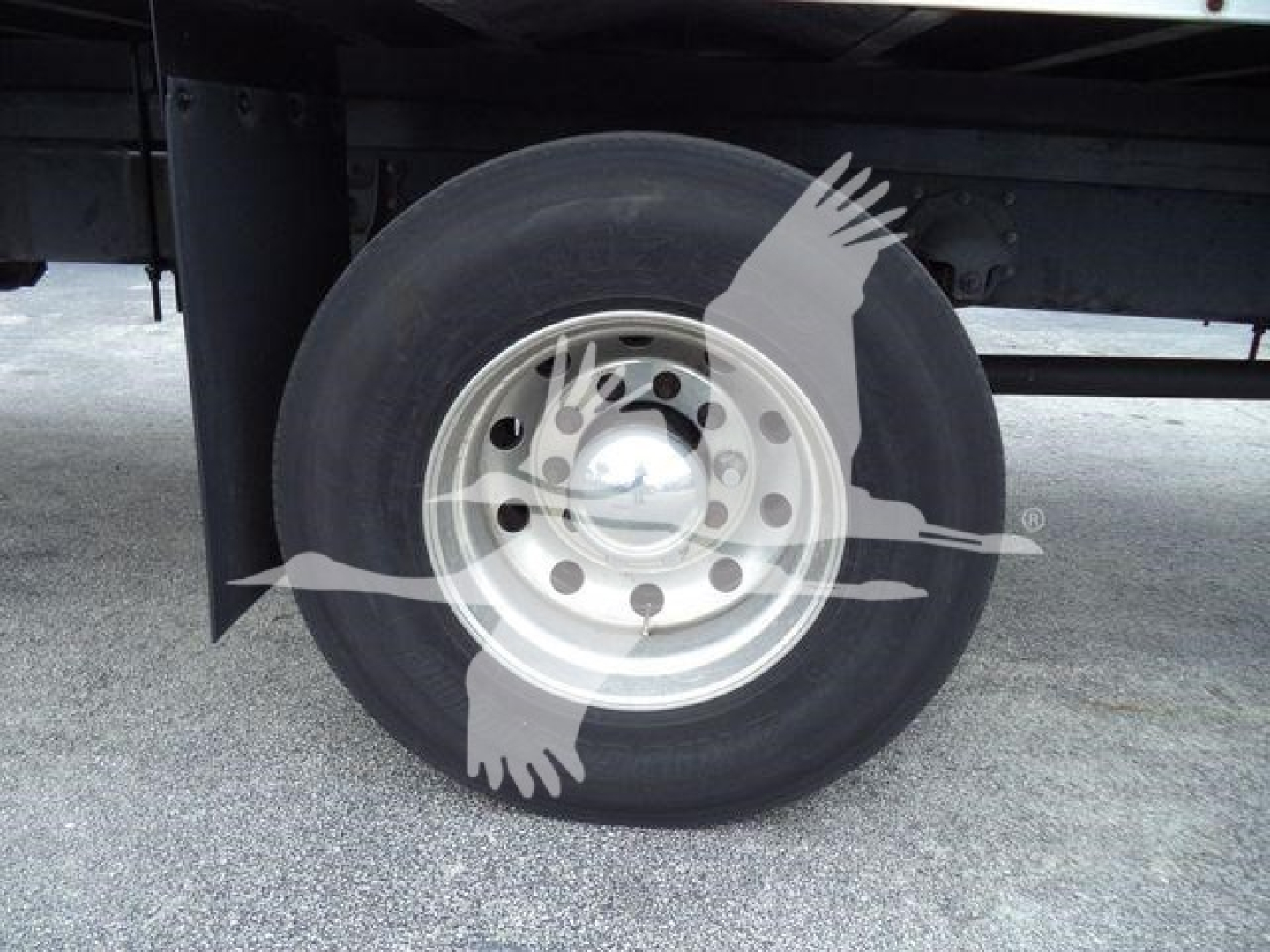 Wheel and tire under truck with steel rim and hubcap; no legible labels visible on the wheel area.