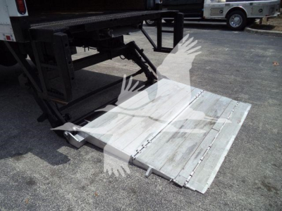 Truck rear with aluminum lane ramp/step extending from trailer, metal platform details visible.