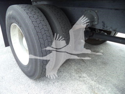 Dual rear wheels with underframe and suspension showing tires and axle components on a Mack MD7 truck.