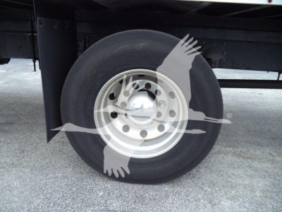 Wheel and tire under truck with steel rim and hubcap; no legible labels visible on the wheel area.