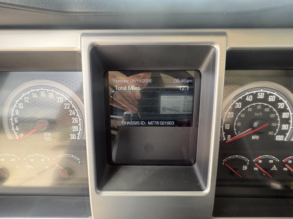 Mack PI64T dashboard center display showing total miles and chassis ID screen between two gauge clusters.