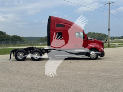 Kenworth T680 truck cab side profile showing sleeper with badge, red paint, tandem rear axles, curb wheels, highway setting.