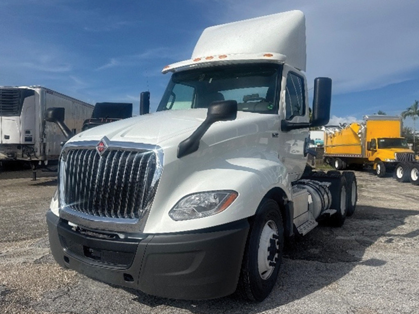 White 2019 International LT625 semi-truck cab with large chrome grille, overhead sleeper fairing, black front bumper, side mirrors.
