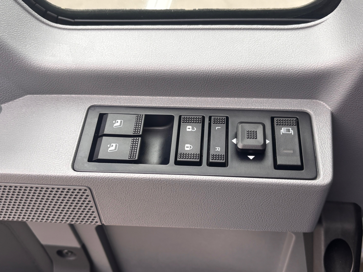 Mack PI64 truck interior switch panel showing window controls and mirror lockout. Visible text on switches: multiple icon-based controls; no legible serials. 