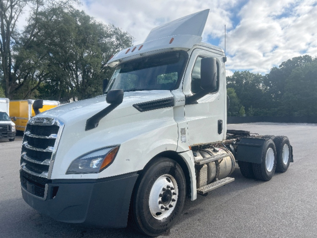 Freightliner Cascadia126 daycab tractor interior left front side; white truck with raised roof; front grille; dual rear axles; fuel tanks; side steps.