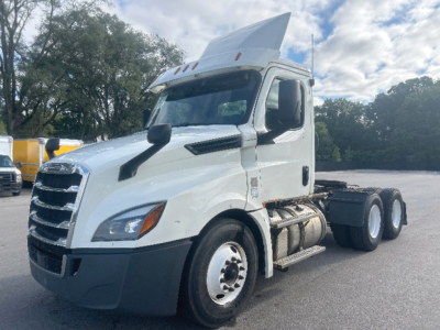 Freightliner Cascadia126 daycab tractor interior left front side; white truck with raised roof; front grille; dual rear axles; fuel tanks; side steps.