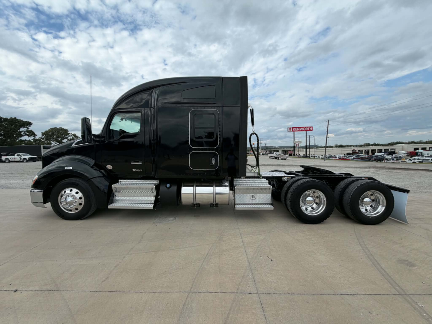 Kenworth T680 tractor cab side profile showing dual rear axles and chrome fuel tanks