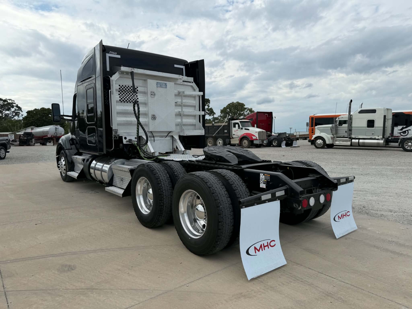 Kenworth T680 rear view showing dual rear axles, fifth wheel, and mud flaps with ‘MHC’ logos.