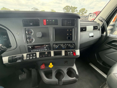 Kenworth T680 dash interior showing instrument cluster, climate controls, radio, and cup holders.