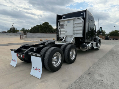 Kenworth T680 truck rear view showing dual rear axle and aluminum fuel tank with silver toolbox, no visible text labels.
