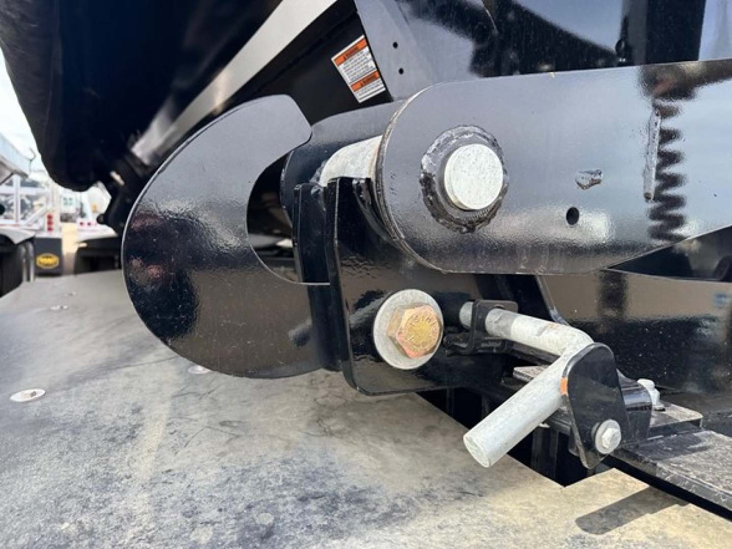 Trailer component showing hitch and latch assembly with bolts and pin for jet air ride side dump system.