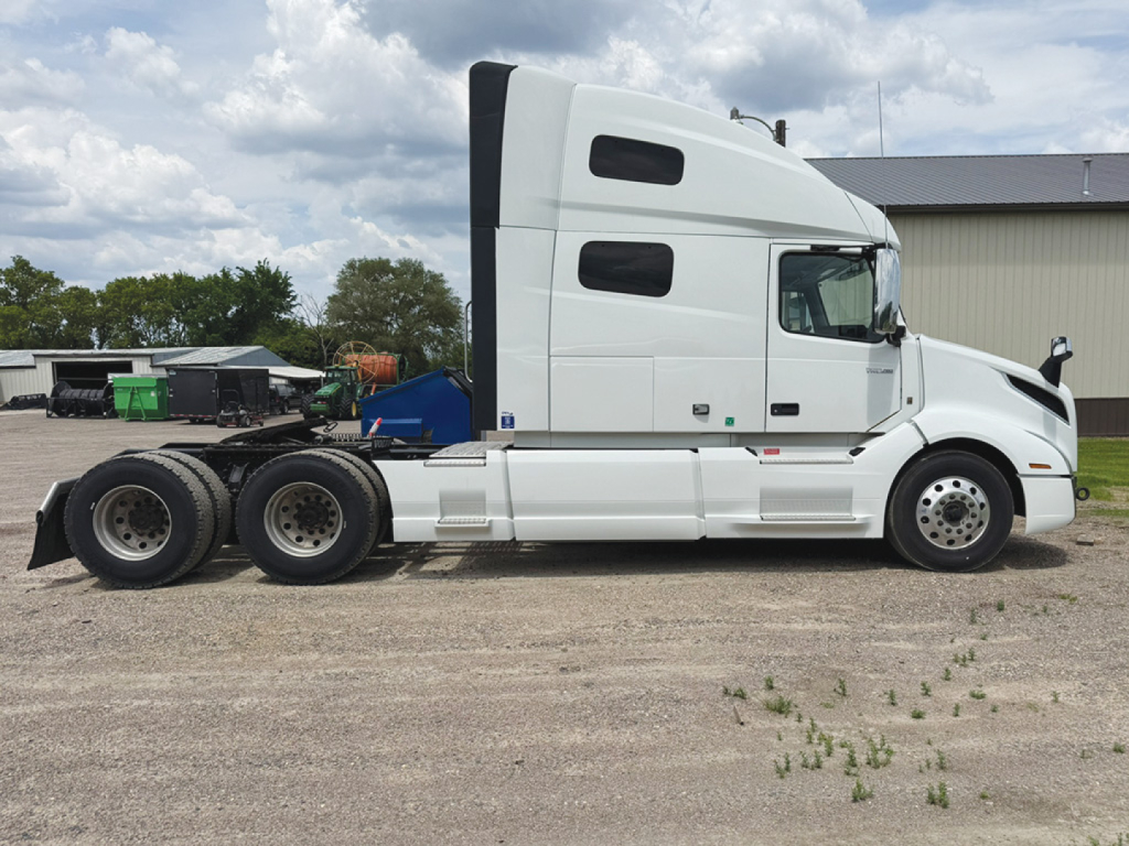 Side view of a 2022 Volvo VNL 760 tractor truck showing sleeper cab, white exterior, tandem rear axles, and fuel tanks.