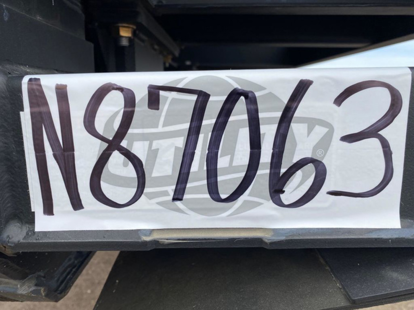 Trailer nameplate with large stock number N87063 mounted on Demco Liquid Tender trailer hitch area.