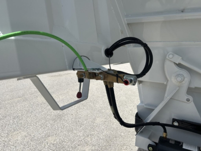 Trailer hitch area showing hydraulic hoses and electrical connectors on a CTS BDT-40 Spring trailer.