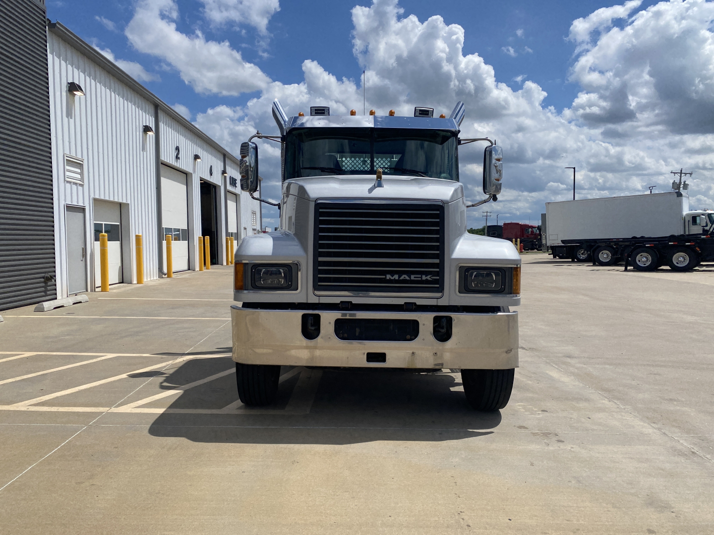 Front view of a 2019 Mack PI64T conventional daycab truck showing large black grille, rectangular headlights, chrome bumper, and label-free hood.