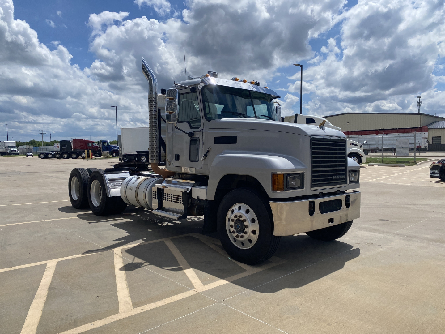 Mack PI64T conventional daycab truck in a parking lot showing side view and cab details.