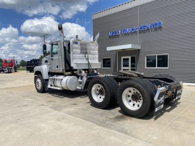 Clean white 2019 Mack PI64T conventional daycab truck with dual rear axles and chrome exhaust stacks parked in front of a used truck center. VIN 1M1PN4GY6KM003905 and stock B3314P.