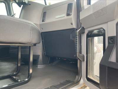 Mack PI64T cab interior showing dashboard area and passenger seat with glove box and open door