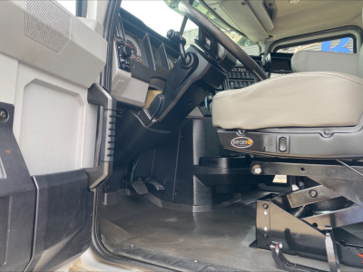 Interior of a 2019 Mack PI64T truck cab showing the driver's seat with Seatz seat base, steering wheel, dashboard, and entryway pedals