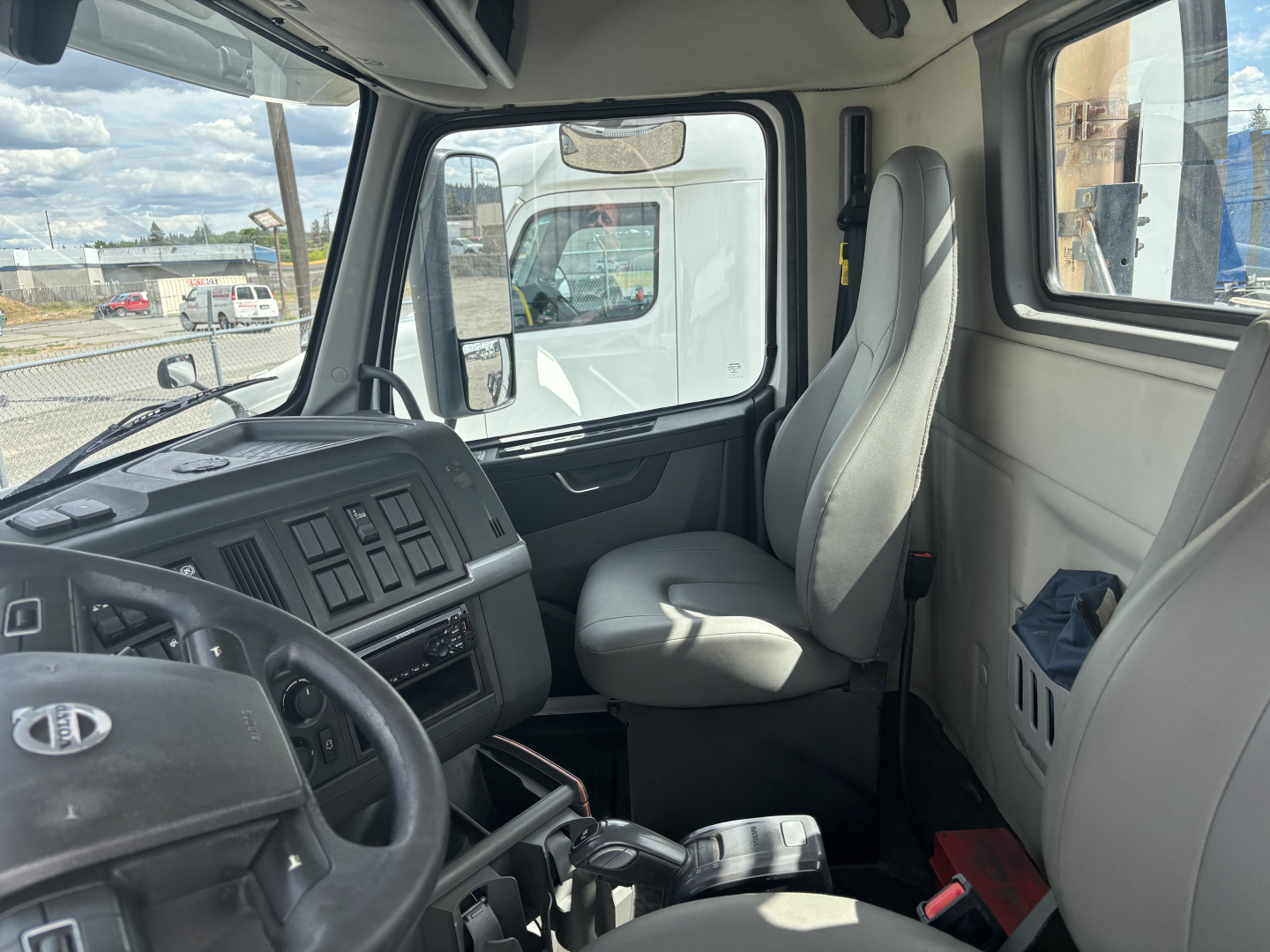Volvo VNL84T300 truck cab interior showing steering wheel, driver seat, and dashboard with control panels.