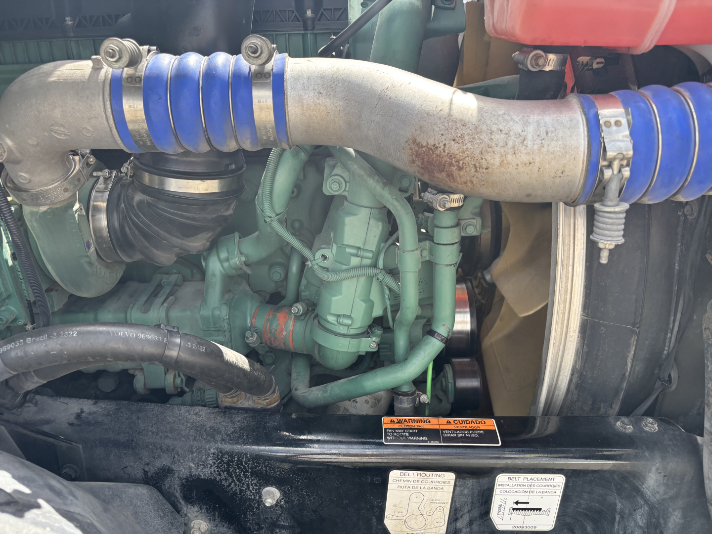 Volvo VNL84T300 engine bay showing green engine block, blue silicone intercooler hoses, and exposed turbo area.