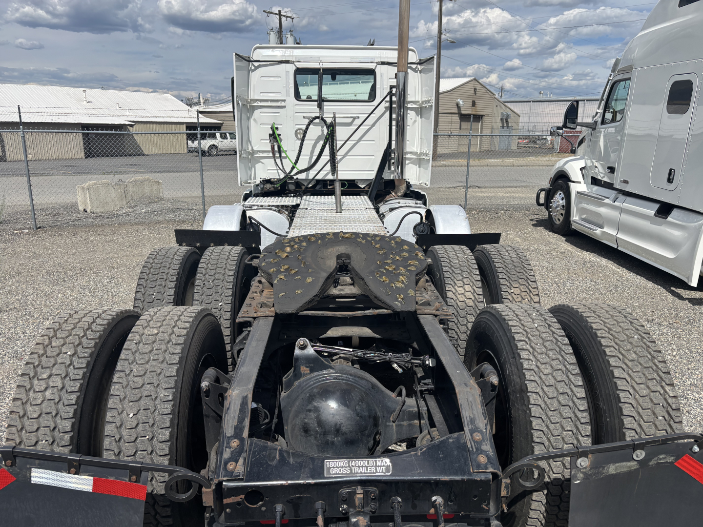 Truck chassis rear view showing dual rear axles, fifth wheel area, and back of cab on a used 2019 Volvo VNL84T300 with visible tires and suspension components.