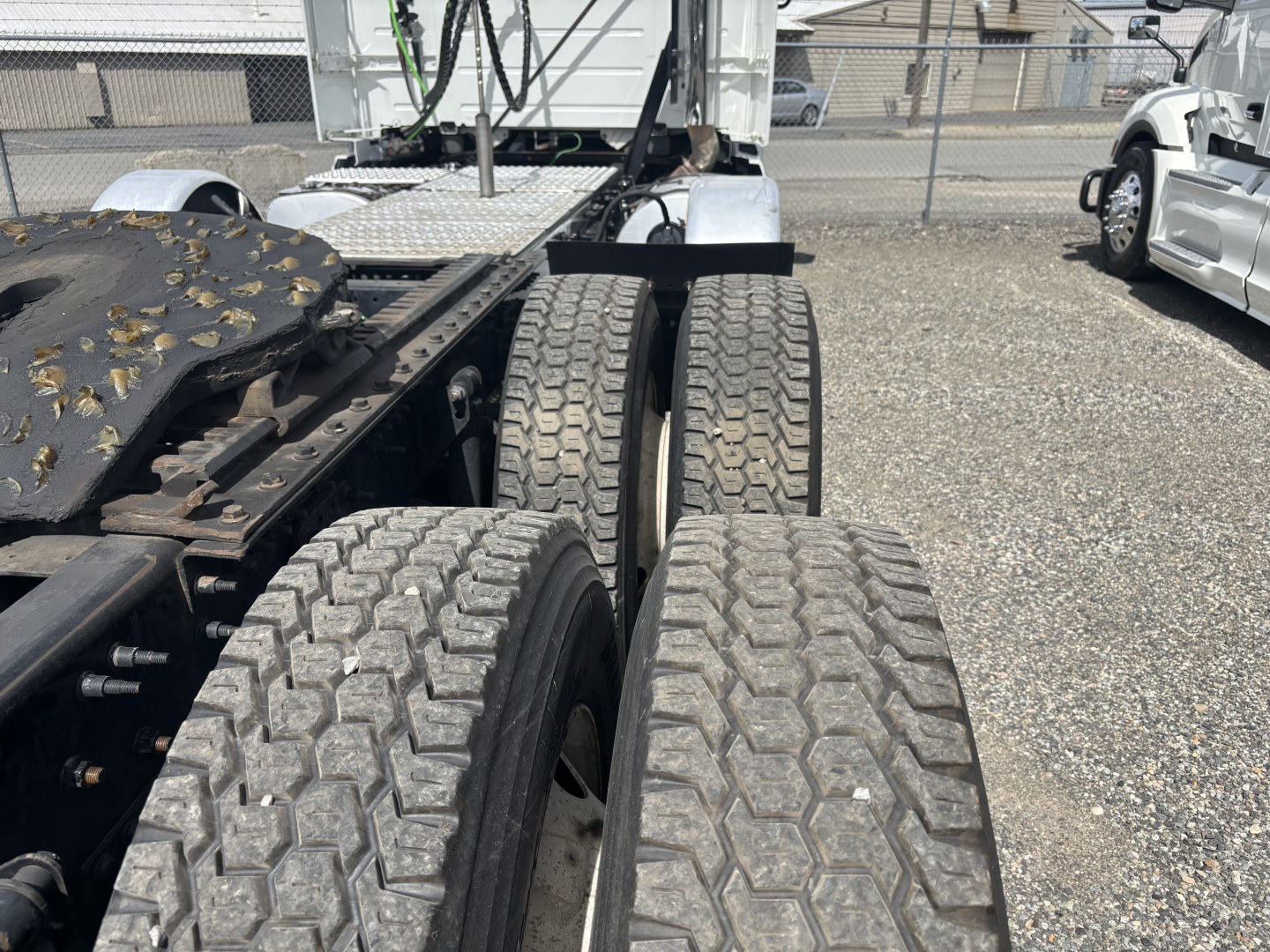 Truck chassis and dual rear axles of a 2019 Volvo VNL84T300 showing the rear wheel area and fifth wheel plate.