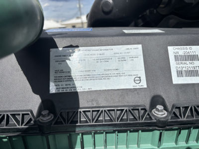 Label on Volvo VNL engine bay with Vehicle Identification Number and serial sticker text; visible text includes chassis ID NR - 204111, serial no D13T211... and a white label with multiple lines of small print.