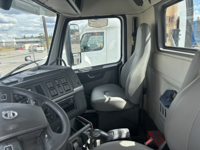 Volvo VNL84T300 truck cab interior showing steering wheel, driver seat, and dashboard with control panels.