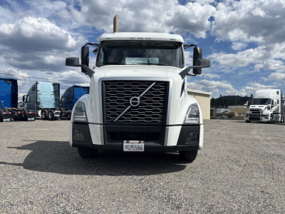 2019 Volvo VNL84T300 conventional daycab truck front view with Volvo emblem grille and license plate in yard.